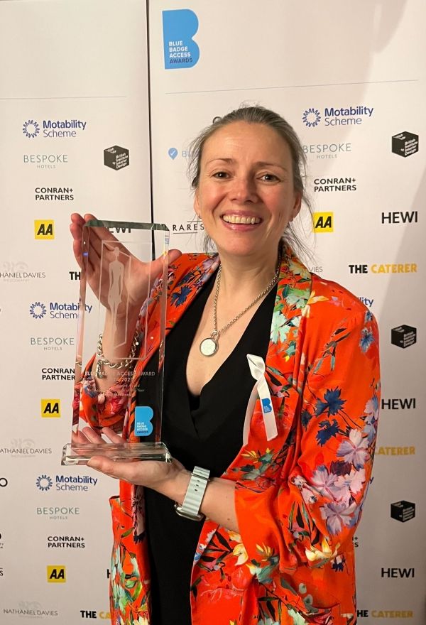 Photo of Antonia holding the Blue Badge Award