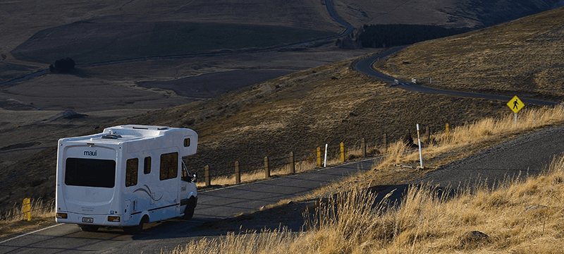 Image of a caravan driving on a country road.