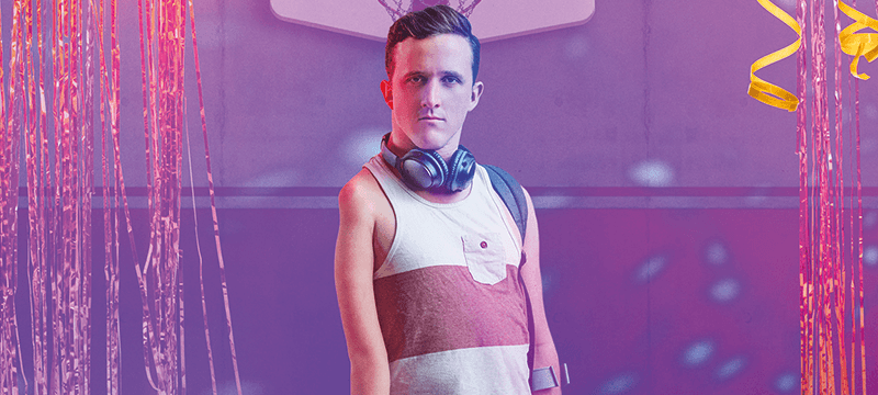 Image of main character standing infront of a purple background.