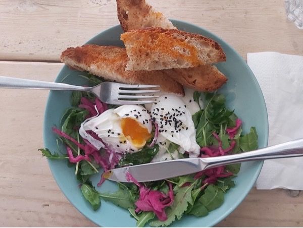 A photo of Tina's eggs and toast with salad on a plate